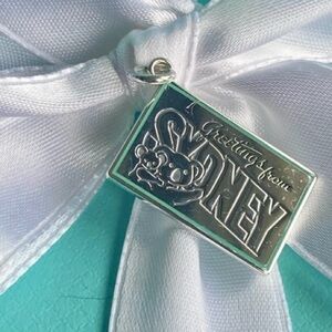 Tiffany & Co.Brand new, sterling silver 
Postcard charm “greeting from Sydney”
